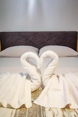 two white swans towels laying on a bed at Hotel Grand in Banja Luka