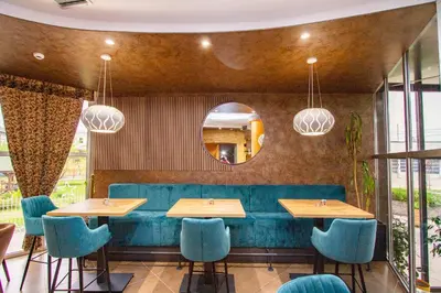 a restaurant with blue chairs and tables and a mirror at Hotel Grand in Banja Luka