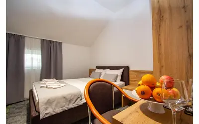 a room with a bed and a table with fruit on it at Hotel Grand in Banja Luka