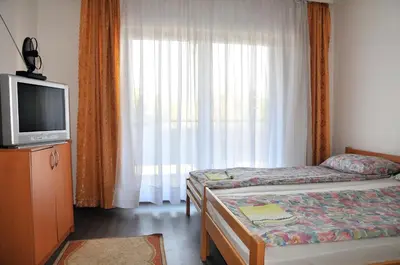 a room with two beds and a tv and a window at Hostel Room in Banja Luka