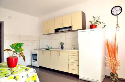 a kitchen with white cabinets and a refrigerator at Hostel Room in Banja Luka