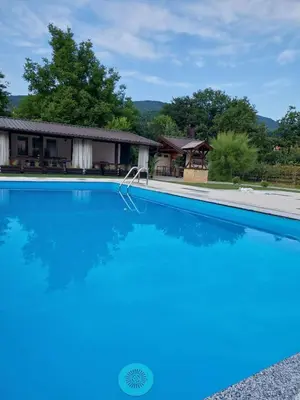 a large swimming pool in front of a house at Motel Maks in Kiseljak