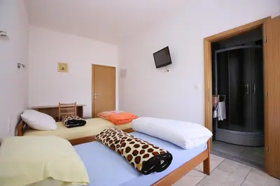 a room with two beds and a flat screen tv at Motel Maks in Kiseljak