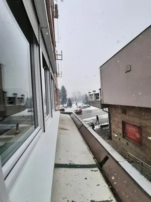 a snow covered sidewalk outside of a building at Apartman Tvrdjava in Banja Luka