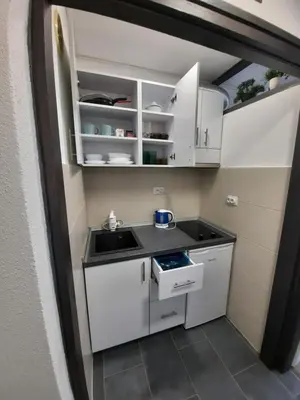 a small kitchen with white cabinets and a sink at Apartman Tvrdjava in Banja Luka