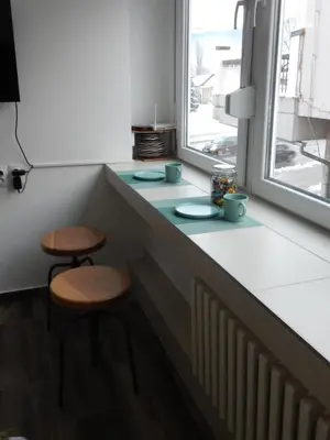 a kitchen counter with two stools and a window at Apartman Tvrdjava in Banja Luka