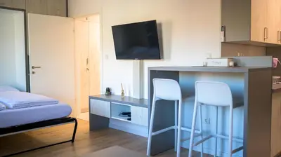 a room with two stools and a desk with a tv at Apartman EpiCent in Tuzla