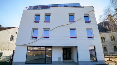 a white building with red windows at Apartman EpiCent in Tuzla