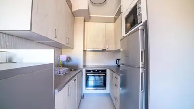 a kitchen with white cabinets and a stainless steel refrigerator at Apartman EpiCent in Tuzla
