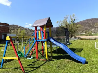 a playground with a slide on the grass at Una Luxury Home in Bihać