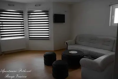 a living room with a couch and a table andools at APARTMANI PETKOVIC in Teslić