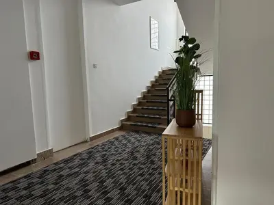 a hallway with a staircase and a potted plant at Royal City Apartments in Jajce