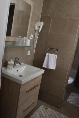 a bathroom with a sink and a shower with a mirror at Royal City Apartments in Jajce