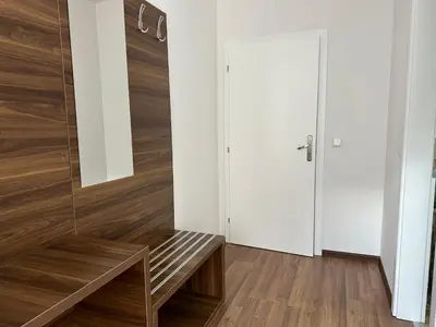 a hallway with a wooden bench and a door at Royal City Apartments in Jajce