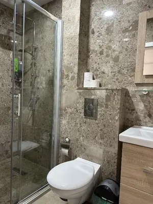a bathroom with a shower and a toilet and a sink at Royal City Apartments in Jajce