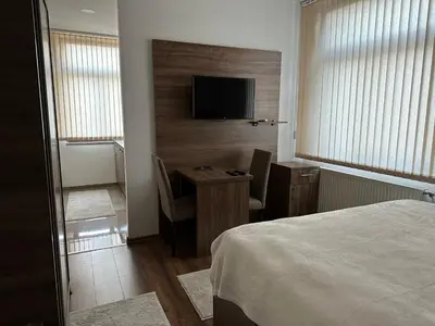a bedroom with a bed and a desk with a television at Royal City Apartments in Jajce