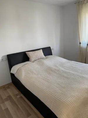 a bed in a bedroom with a black and white comforter at Oaza in Jelah
