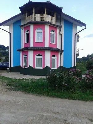 a pink and blue building with a balcony at Vila Anđelija in Velika Kladuša