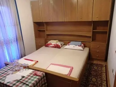 a small room with a bed and a cabinet at Vila Anđelija in Velika Kladuša