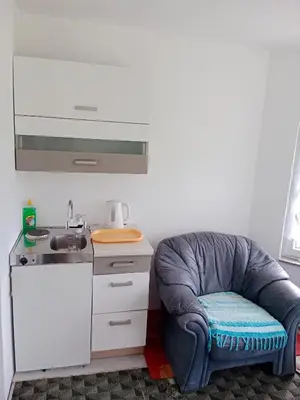 a chair in a kitchen with a sink at Vila Anđelija in Velika Kladuša