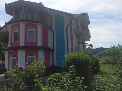 a pink and blue building with a balcony at Vila Anđelija in Velika Kladuša