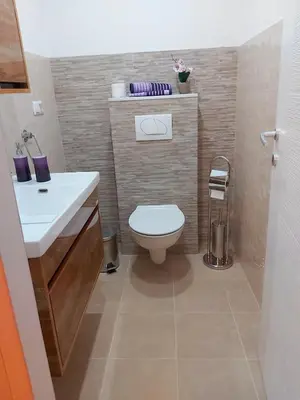 a bathroom with a white toilet and a sink at apartman UNO in Jajce