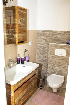 a bathroom with a white sink and a toilet at apartman UNO in Jajce
