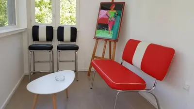 a room with three chairs and a painting on the wall at Vila Galerija in Banja Luka
