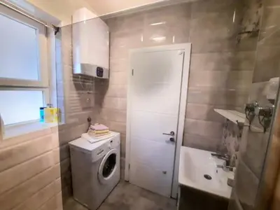 a bathroom with a washing machine and a sink at Vila Galerija in Banja Luka