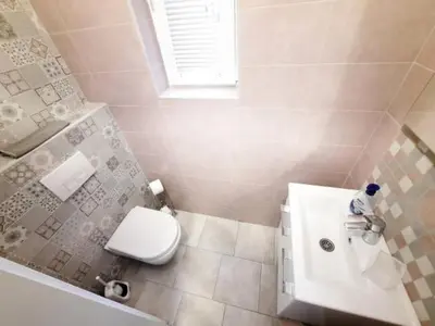 a bathroom with a white toilet and a sink at Vila Galerija in Banja Luka