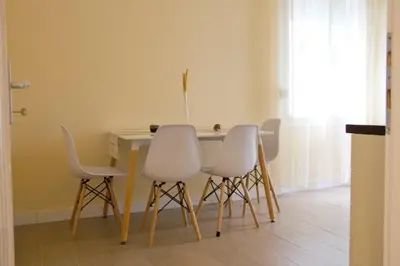 a dining room table with four white chairs around it at Vila Galerija in Banja Luka