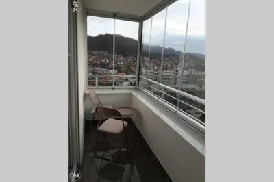 a balcony with two chairs and a view of a city at Stan, Apartman Eleven-Elf Tuzla centar, NOVO in Tuzla