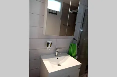 a bathroom with a white sink and a mirror at Stan, Apartman Eleven-Elf Tuzla centar, NOVO in Tuzla