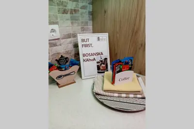 a cake sitting on a counter next to a sign at Stan, Apartman Eleven-Elf Tuzla centar, NOVO in Tuzla