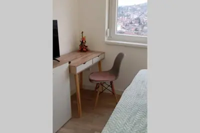 a room with a desk and a chair and a window at Stan, Apartman Eleven-Elf Tuzla centar, NOVO in Tuzla