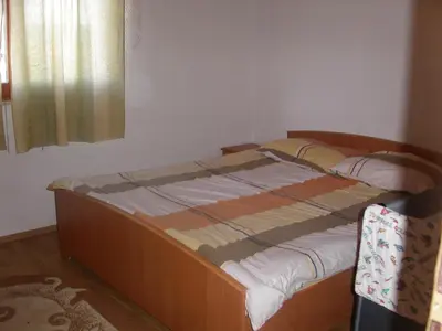a small bed in a room with a window at Apartments Marevic in Kupres