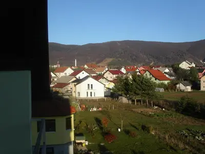 a village with houses and mountains in the background at Apartments Marevic in Kupres