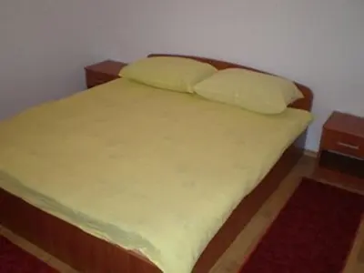 a bedroom with a bed with yellow sheets and pillows at Apartments Marevic in Kupres