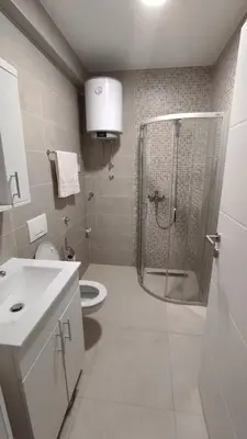 a bathroom with a shower and a toilet and a sink at M&I Apartment in Doboj