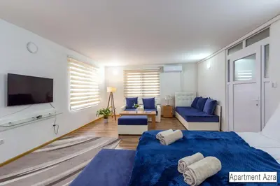 a bedroom with a blue bed and a tv at Pansion Beg in Tuzla