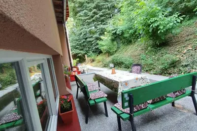 a patio with a table and chairs on a porch at Pansion Beg in Tuzla