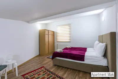 a bedroom with a bed with a purple blanket at Pansion Beg in Tuzla