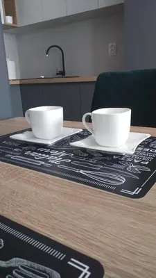 two white cups sitting on top of a table at Apartman Green Lux in Banja Luka