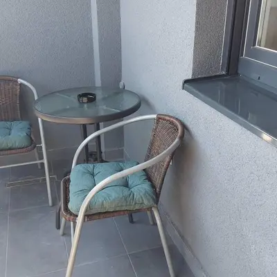 a table and a chair with a glass table and a table at Apartman Green Lux in Banja Luka