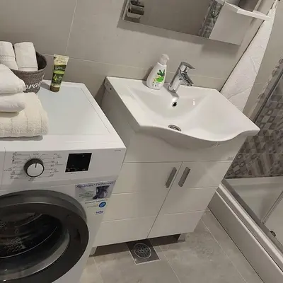 a bathroom with a washing machine and a sink at Apartman Green Lux in Banja Luka