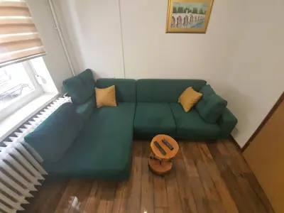 a living room with a green couch with yellow pillows at Apartment City Centar in Banja Luka