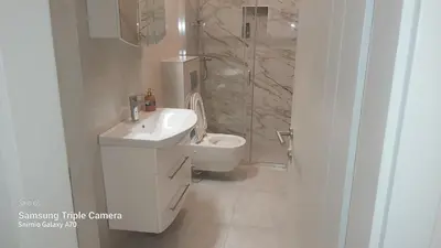a bathroom with a toilet and a sink and a shower at AMY APARTMAN in Tuzla