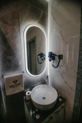a bathroom with a sink and a mirror at Hotel Vertigos in Tuzla