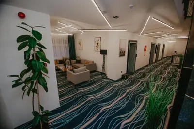 a living room with a couch and a plant at Hotel Vertigos in Tuzla