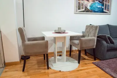 a living room with a table and two chairs and a couch at Apartman Royal 2 in Doboj